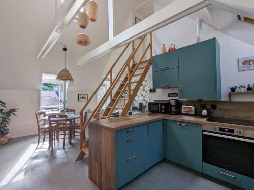 uma cozinha com armários azuis e uma sala de jantar em Appart'Wilson em Binic