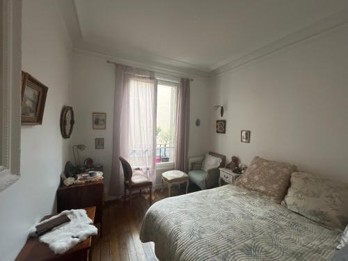 une chambre avec un lit, un bureau et une fenêtre dans l'établissement Belle chambre à Montmartre, à Paris