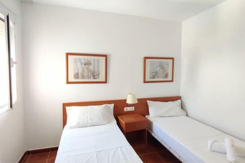- 2 lits dans une chambre aux murs blancs dans l'établissement Acogedor Ático en El Mirador, à Alcaidesa