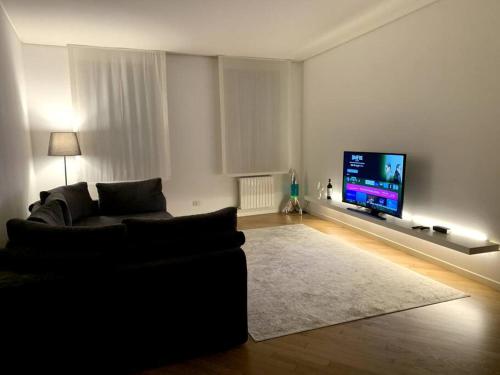 sala de estar con sofá y TV de pantalla plana en Your Loft - Treviso, en Treviso