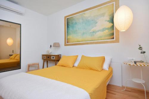 a bedroom with a bed and a painting on the wall at Apartment Pepica in Postira