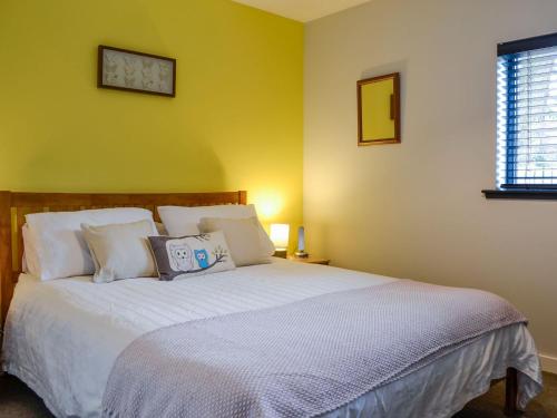 um quarto com uma cama grande e almofadas brancas em Cedar Cottage em Aboyne