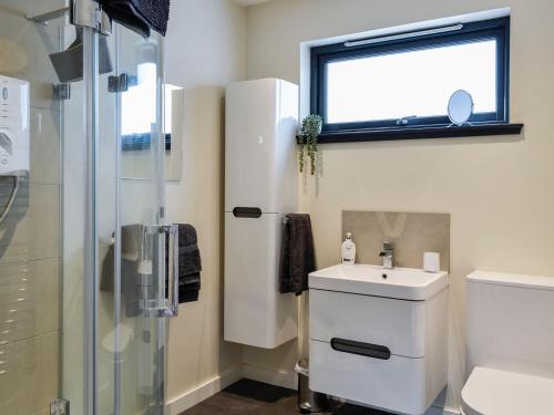 a bathroom with a sink and a shower at Cedar Cottage in Aboyne