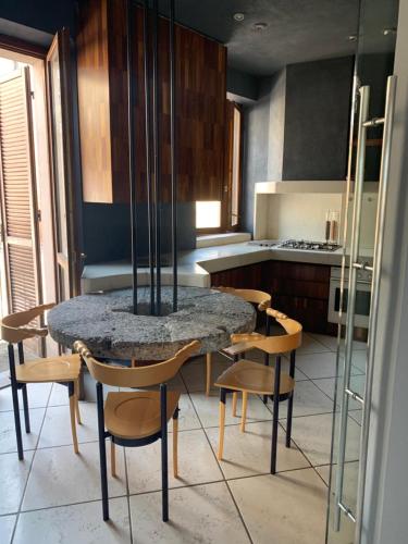 a kitchen with a table and chairs in a room at Casa Macina in CastellʼAlfero