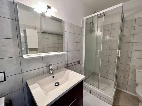 La salle de bains blanche est pourvue d'un lavabo et d'une douche. dans l'établissement T3 6 personnes avec terrasse, wifi, climatisation, à Canet