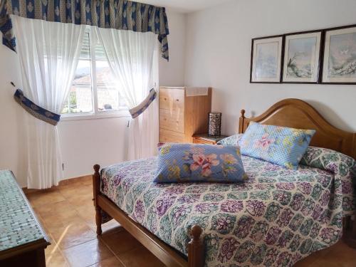 1 dormitorio con cama y ventana en Casa Los Geranios, en Pontevedra