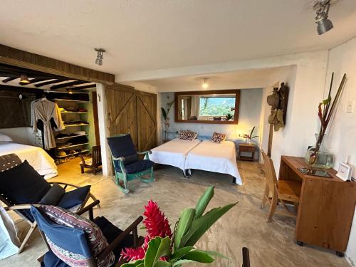 a bedroom with a bed and a living room at Suíte e sala - Vista Barra do Sahy in São Sebastião