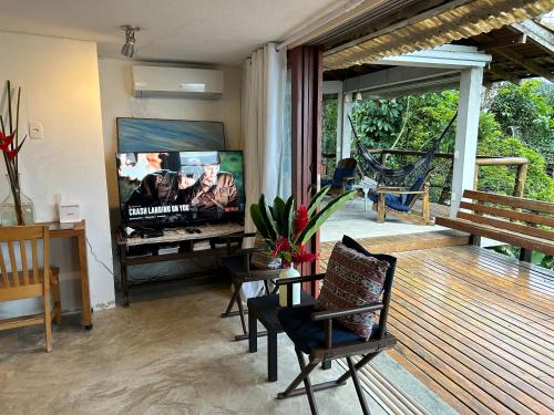 a living room with a flat screen tv on a deck at Suíte e sala - Vista Barra do Sahy in São Sebastião