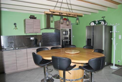 a kitchen with a wooden table and black chairs at Maison de campagne avec piscine in Parigny-les-Vaux