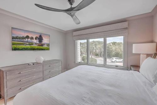 a bedroom with a white bed and a ceiling fan at New Listing! Seagrove Villa 3A - Luxurious Ocean View! in Isle of Palms