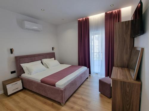 a bedroom with a bed and a television in it at White Villa in Përmet