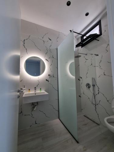 W łazience znajduje się umywalka i lustro. w obiekcie White Villa w mieście Përmet