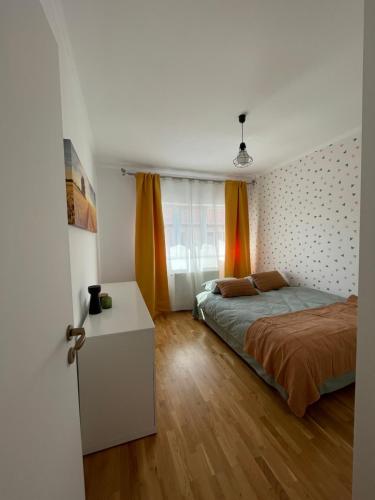 a bedroom with a bed and a table in a room at Bliss Râșnov in Râşnov