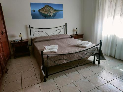una camera da letto con un letto e due asciugamani di Casa Elce a Iglesias