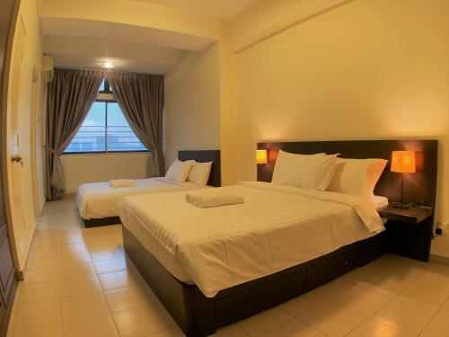 Habitación de hotel con 2 camas y ventana en Bukit Bintang Apartment by Sarah's Lodge @ Fahrenheit88 en Kuala Lumpur