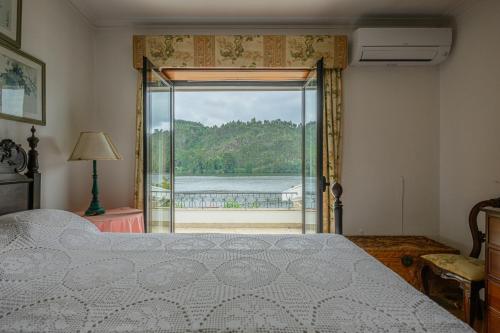 a bedroom with a bed and a view of the water at Casa do Pombal in Medas