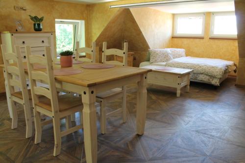 Hrad Vildstejn في Skalná: غرفة طعام مع طاولة وكراسي وأريكة