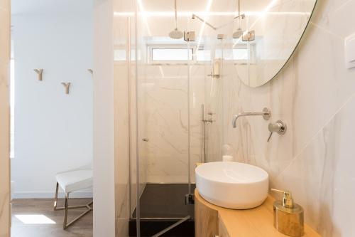 La salle de bains est pourvue d'un lavabo et d'un miroir. dans l'établissement Lisbon Airport Suites, à Lisbonne
