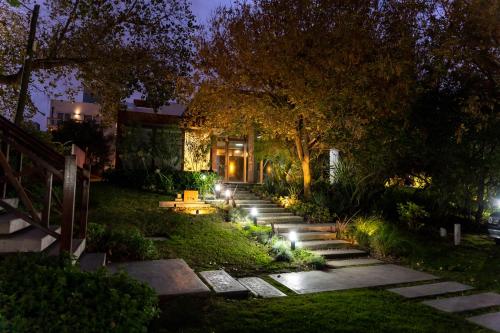 a garden at night with steps leading up to a house at O2 Hotel Valeria del Mar in Valeria del Mar