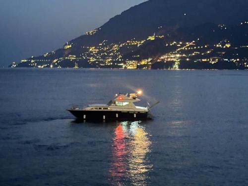 a boat sitting on the water at night at Amalfi Coast Yacht in Minori