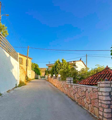 an empty street next to a brick wall at Anassa's Apartment - Άνασσα Διαμέρισμα in Katsíngrion
