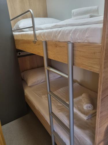 a bunk bed with a ladder on a bunk bed at Hipo camp Mobil home Arta in Pakoštane