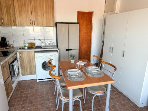 a kitchen with a table and chairs in a kitchen at Casa da Lena in Fuzeta