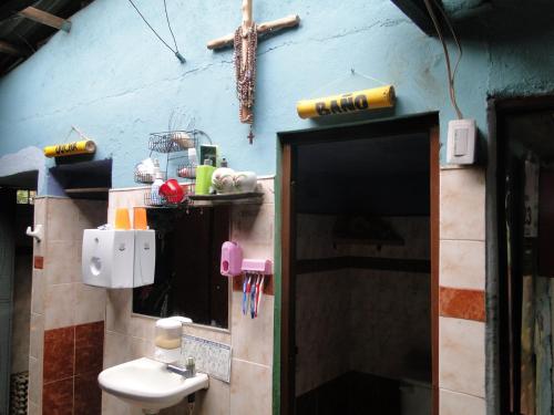 a bathroom with a sink and a cross on the wall at Finca Ecoturística Tierra Blanca in La Laja