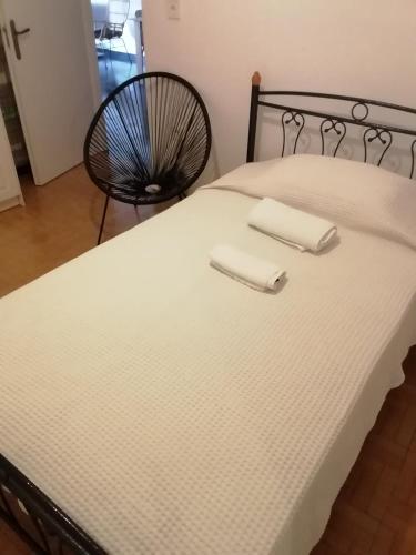 a bed with two white towels on top of it at Andros Breeze in Batsi