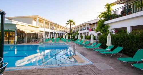 a hotel with a pool with chairs and umbrellas at Sofia's Hotel in Kalamaki