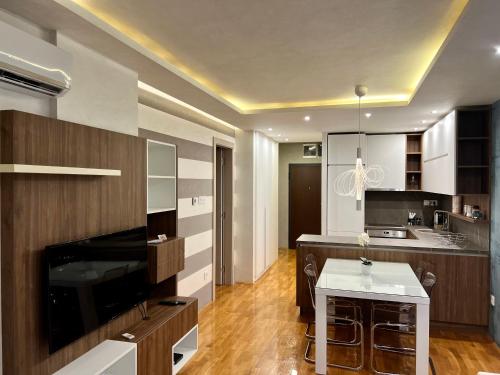 een grote keuken met houten kasten en een witte tafel bij Midtown Boutique Apartment in Novi Sad