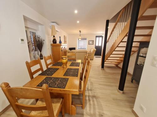 une salle à manger et un salon avec une table et des chaises dans l'établissement Maison familiale à Raon-l'Étape - 3 chambres, balcon sur rivière, proche commodités et activités - FR-1-589-594, à Raon-lʼÉtape