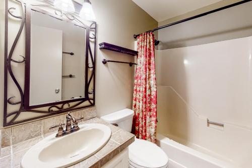 a bathroom with a sink and a toilet and a mirror at Trail Creek 33 in Killington