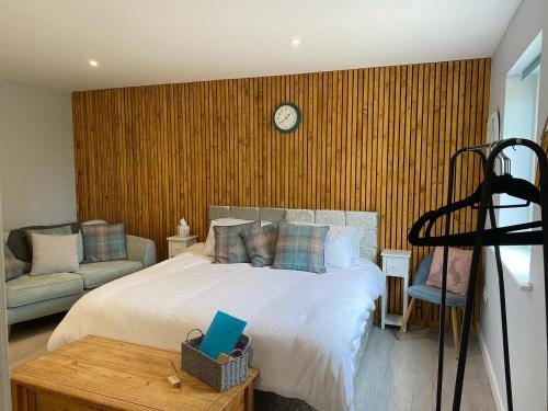 a bedroom with a bed and a clock on a wall at Sandy Top in Saint Abbs