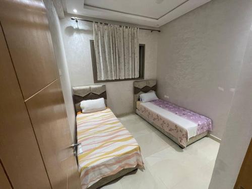 a small room with two beds and a door at Bahia beach . Plage dahomey in Bouznika