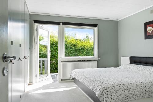 a white bedroom with a bed and a window at Villa nära Varberg och Ullared in Varberg