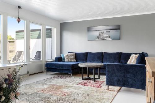 a living room with a blue couch and a table at Villa nära Varberg och Ullared in Varberg