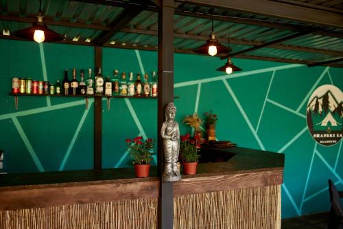 a bar with a statue sitting at the counter at glamping Shangri la 