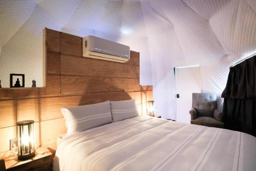 1 dormitorio con cama blanca y techo en Casa Domo Glamping by BajaHomeStays, en Francisco Zarco