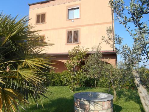 a house with a barrel in front of it at The Garden Guest House in Divjakë