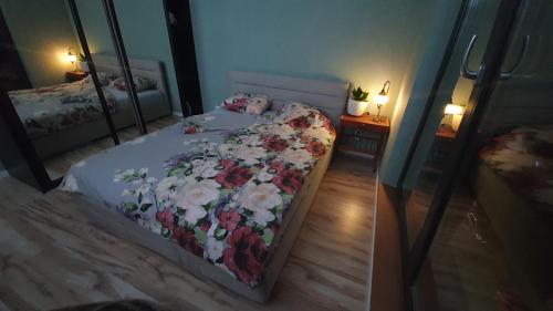 Un dormitorio con una cama con flores. en Apartment in city center, en Przemyśl