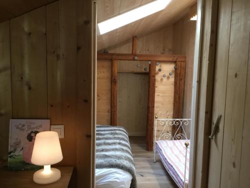 Cette petite chambre comprend un lit et une lampe. dans l'établissement La Chabraque, à Le Barboux