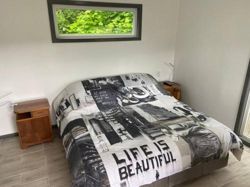 een slaapkamer met een bed met een zwart-wit dekbed bij Casa Nueva en Parcela de Agrado in Valdivia