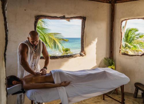 un hombre cortando a un hombre en una cama en Amansala Resort, en Tulum