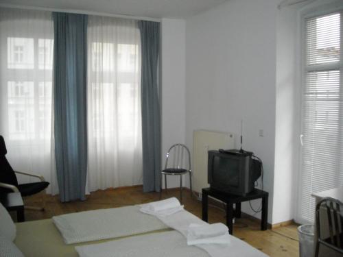 a living room with a tv and a bed at Pension Mitte in Berlin