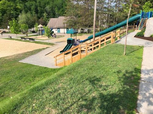 a playground with a slide in a park at Le Cozy Nest by Gestion ELITE in Mont-Tremblant