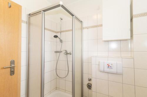 une douche avec une porte vitrée dans une salle de bain dans l'établissement Cuxhaven Fewo Döse Oasis-04, à Döse