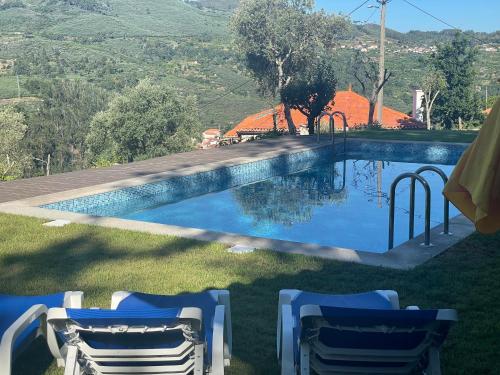 a swimming pool with two lawn chairs next to it at Quintinha de Pinouco in Resende