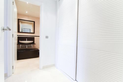 een badkamer met een schuifdeur naar een wastafel bij J Tramuntana Planet Costa Dorada in Salou