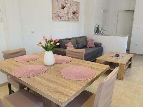杜格普利耶的住宿－Apartment Radoš，用餐室配有带粉红色地方垫的木桌
